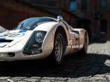 a white and blue race car parked on a cobblestone street