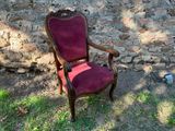 une chaise rouge posée devant un mur de pierre