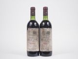 deux bouteilles de vin rouge posées l'une à côté de l'autre sur une surface blanche