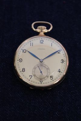 a silver pocket watch with blue hands on a black surface