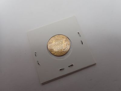 une pièce d'or posée sur un morceau de papier