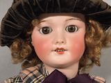 a close up of a doll wearing a hat and dress