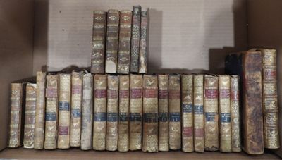 many old books in a cardboard box on the shelf