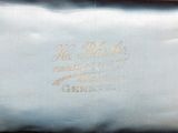 a silver purse with a gold writing on it