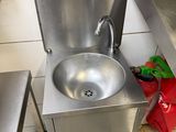 a sink in the middle of a kitchen with a red bag