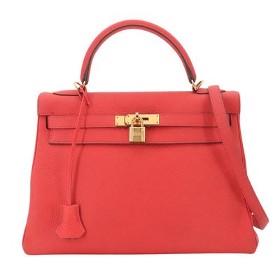 un sac à main en cuir rouge muni d'un fermoir doré sur la poignée