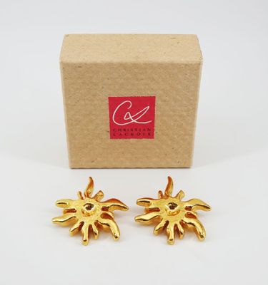 a pair of gold tone sunbursts in a cardboard box