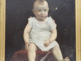 portrait d'un bébé en robe blanche, assis sur une couverture rouge