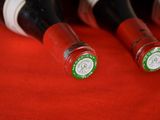 several bottles of wine are lined up on a red surface
