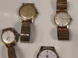 Trois montres sont posées les unes à côté des autres sur une surface blanche.