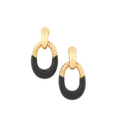 une paire de boucles d'oreilles noires et dorées sur fond blanc