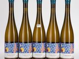 quatre bouteilles de vin sont alignées sur une surface blanche