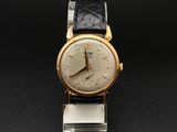 une vieille montre-bracelet en or avec un bracelet en cuir noir