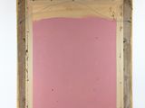 an old wooden frame with a pink wall in the background