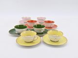 many cups and saucers sitting on a white table