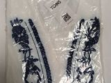une chemise blanche à fleurs bleues, rangée dans un sac en plastique