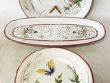three plates with floral designs are sitting on a table
