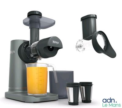une photo d'un extracteur de jus avec un verre de jus d'orange