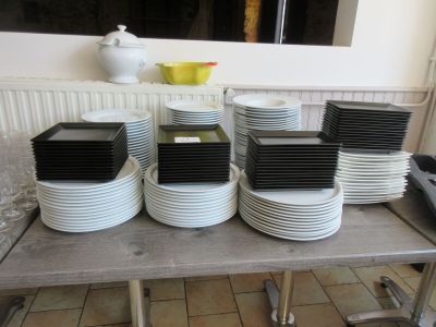 de nombreuses assiettes empilées sur une table dans la cuisine