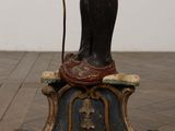 a statue of a man with a cane on a pedestal
