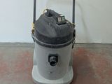 a vacuum that is sitting on the floor next to a wall
