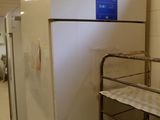 un réfrigérateur blanc sur lequel est apposée une étiquette bleue, dans une pièce
