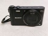 a black digital camera sitting on a white surface