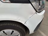 a white car that has a dent in the front of it