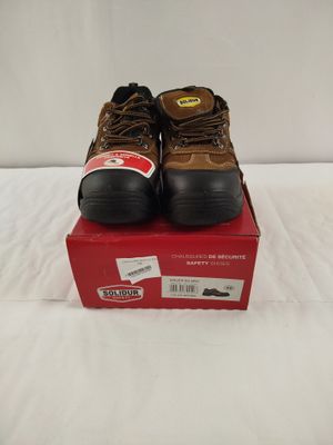 men ' s brown work boots on top of a red box on a bed