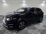 un SUV Nissan noir garé sur un sol à damier dans un garage