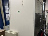 une photo d'un réfrigérateur dans une pièce où se trouvent de nombreuses armoires