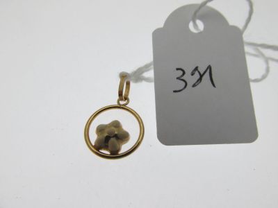 une image représentant un pendentif en or avec une fleur à l'intérieur