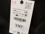 the back of a black sweater with a white tag on it