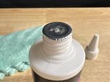 a bottle of glue sitting on a table next to a towel