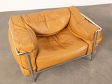 an image of a brown leather chair sitting on top of a cement floor