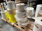 many rolls of paper sitting on a pallet in a warehouse