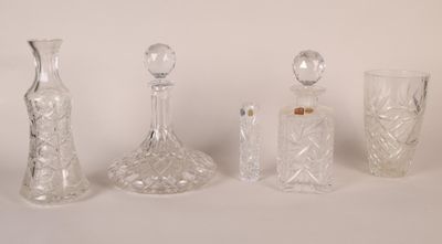 four glass bottles and a glass vase sitting on a white surface