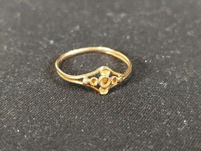 gros plan d'une bague en or sur une surface noire