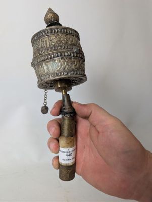 a person holding a metal bell with a chain around it