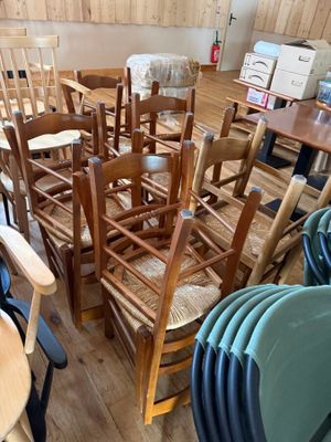 de nombreuses chaises et tables dans une pièce aux murs en bois
