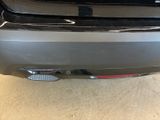 the rear end of a silver car with a red tail light