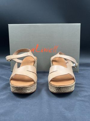 une paire de sandales pour femme avec une boîte sur fond bleu