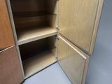 a wooden cabinet with two doors open on a gray surface