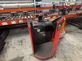 a close up of a forklift in a warehouse with a conveyor belt