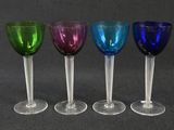 four wine glasses are lined up in a row on a table