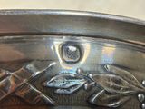 a close up of a silver plate with a bird on it