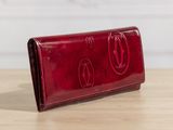 a red wallet sitting on top of a wooden table