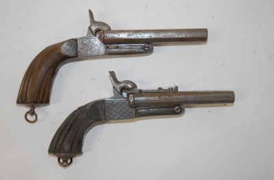 two old guns are on a white surface with a white background