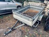 une petite remorque garée à côté d'une voiture