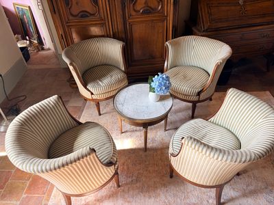 plusieurs chaises et une table dans une pièce, avec une armoire en arrière-plan
